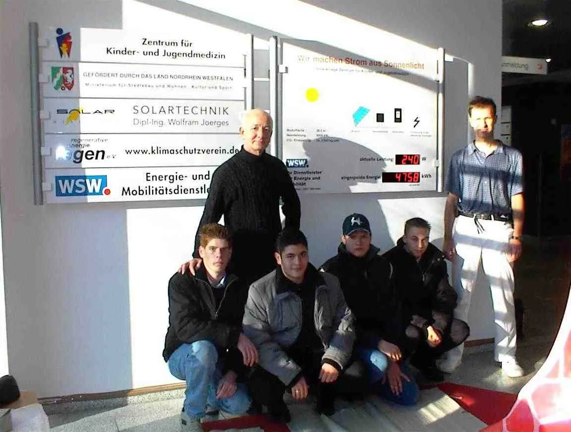 Sechs Beteiligte stehen nach der Montage vor den Hinweis- und Anzeigetafeln in der Eingangshalle der Klinik