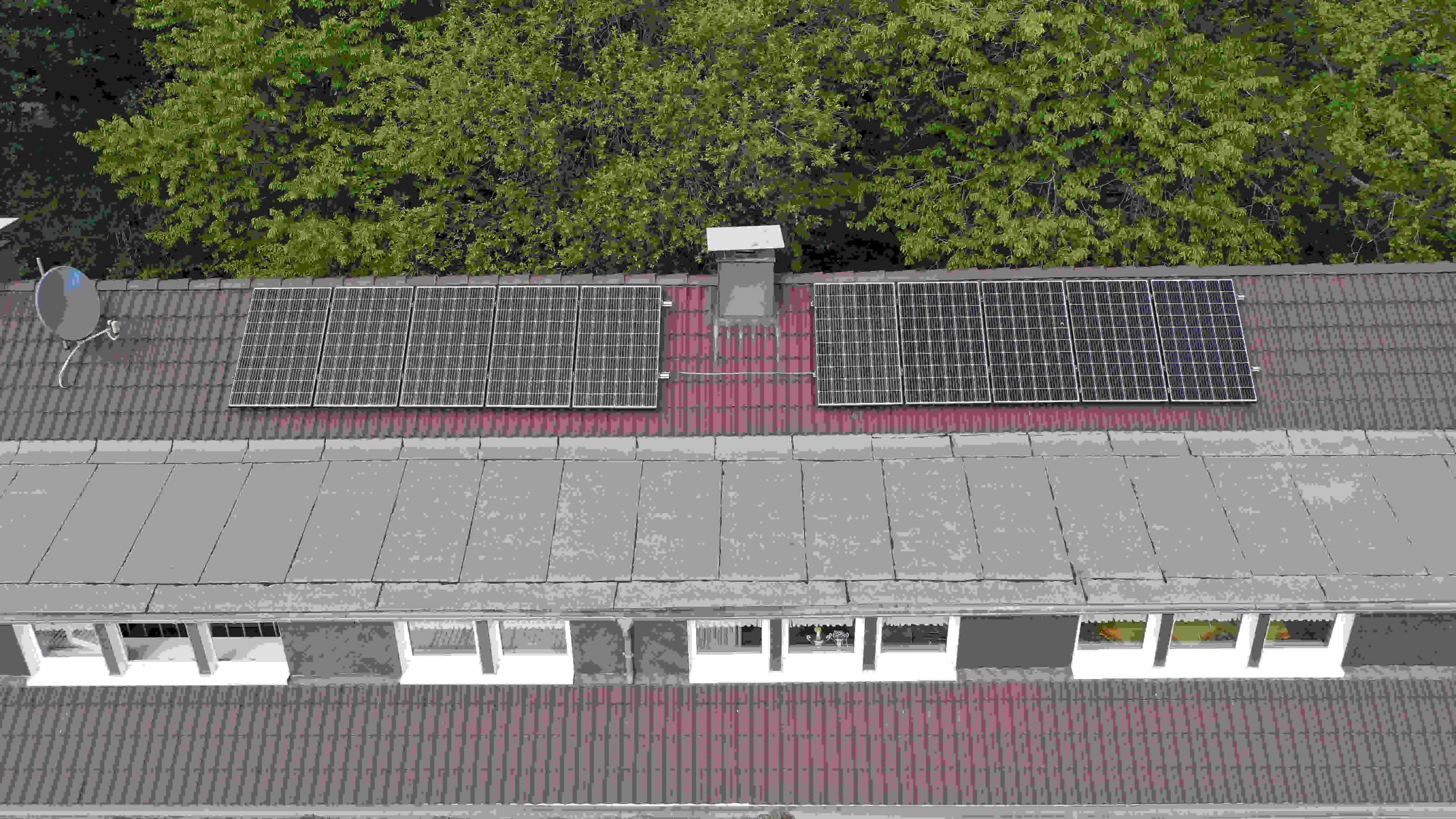 Luftaufnahme des Bootshauses am Beyenburger Stausee mit zwei Reihen Solarmodulen auf dem Ziegeldach